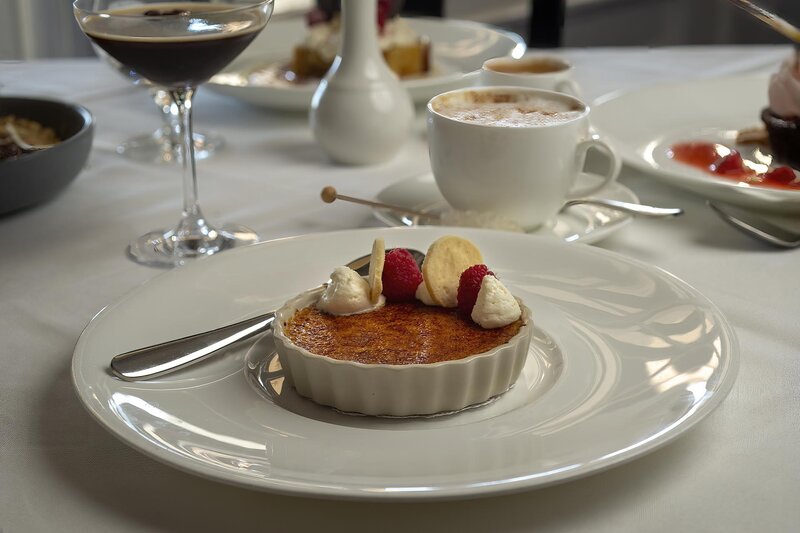 Creme Brulee dessert topped with raspberries and cream