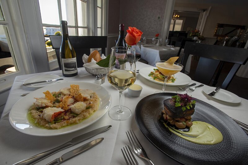 Multiple entrees with white and red wine and flower center piece